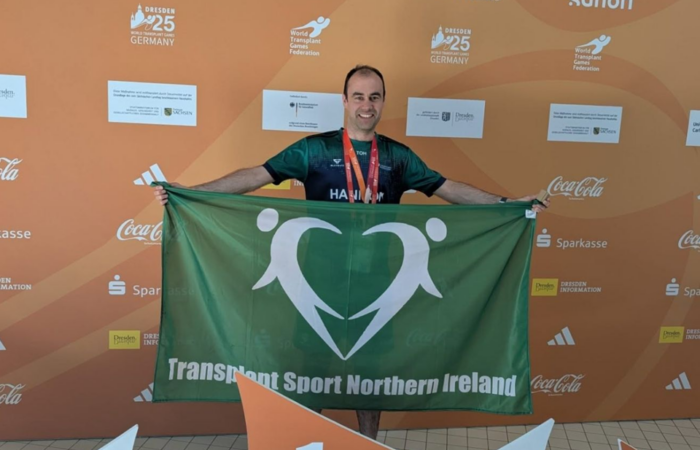Man with gold medal and flag